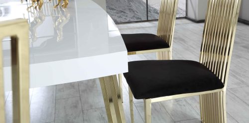 Mesut matgrupp med svarta stolar, vitt bord och guldfärgade ben.